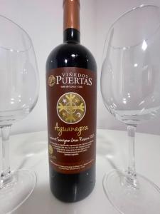 una botella de vino junto a dos copas de vino en Habitación doble con Jacuzzi, en Curicó