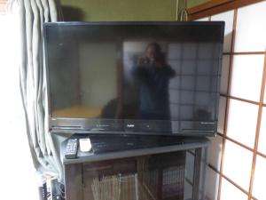 日田グリーンツーリズム花の木 في هيتا: شخص يلتقط صورة للتلفاز