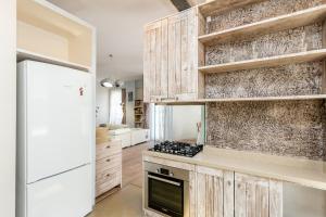 Una cocina con gabinetes de madera y un refrigerador blanco. en Cityview Elegance, en Tiflis