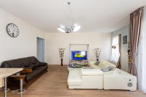 Una sala de estar con un sofá y un televisor en Cityview Elegance, en Tiflis
