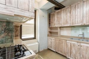 Una cocina con gabinetes de madera y un fregadero. en Cityview Elegance, en Tiflis