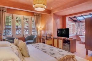 a bedroom with a large bed and a television at Unseen Boutique Hotel, Assagao in Assagao