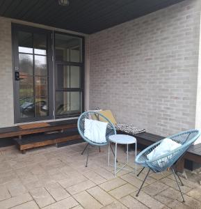Dos sillas y una mesa en un patio. en Odense Garden Apartment, en Odense