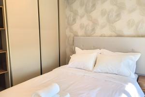 un dormitorio con una cama con sábanas y almohadas blancas en Moderno y equipado, cerca del Paseo la Galeria, en Asunción 15 fotos más