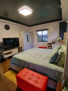 Stella Dream Escape في مانيلا: غرفة نوم مع سرير كبير وتلفزيون بشاشة مسطحة