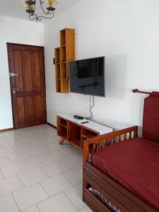 a living room with a bed and a flat screen tv at Dpto céntrico cómodo in Miramar