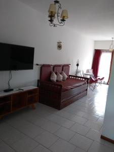 a living room with a red couch and a flat screen tv at Dpto céntrico cómodo in Miramar