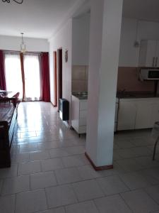 a large kitchen with a tile floor and white cabinets at Dpto céntrico cómodo in Miramar +1 photo