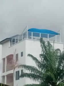 ein Gebäude mit einem blauen Regenschirm darauf in der Unterkunft Regal Royal Suites in Kokrobite