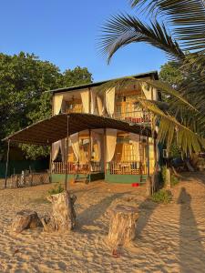a house on the beach with a palm tree at Secret Garden Agonda Beach Resort in Agonda +69 photos