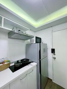 a small kitchen with a refrigerator and a stove at Cozy room at Hillside2 Condo in Chiang Mai +7 photos