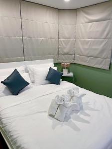 a white bed with blue pillows and towels on it at Cozy room at Hillside2 Condo in Chiang Mai