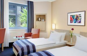 a hotel room with two beds and a window at Hotel Nürnberg City Center by Leonardo Hotels in Nürnberg +19 photos
