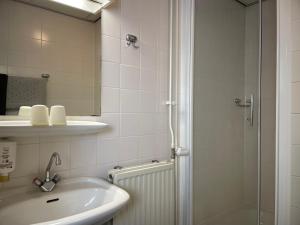 ein weißes Badezimmer mit Waschbecken und Dusche in der Unterkunft Hotel Willemstad in Willemstad + 59 Fotos