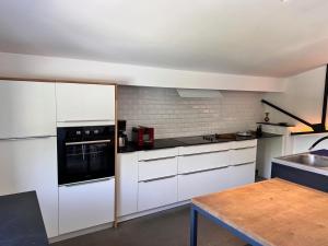 a kitchen with white appliances and a wooden table at le gite de l'atelier in Gray
