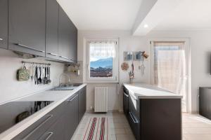 a kitchen with gray cabinets and a sink and a window at La dimora del Lago in Colico