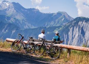 Demeure Sauvage - Étage 1 في Villard-Reculas: شخصان يجلسان على مقعد مع دراجتيهما