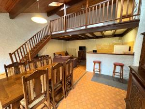 Maison Usclade Murat-le-Quaire في Murat-le-Quaire: غرفة معيشة مع درج وطاولة وكراسي