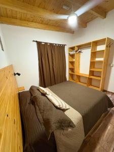 a bedroom with a bed and a book shelf at Cabaña tranquila y gran parque ideal para parejas in Villa Anizacate +10 photos