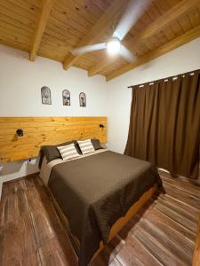 a bedroom with a bed in a room with wooden ceilings at Cabaña tranquila y gran parque ideal para parejas in Villa Anizacate