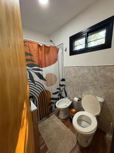 a bathroom with a toilet and a shower curtain at Cabaña tranquila y gran parque ideal para parejas in Villa Anizacate