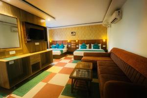 a hotel room with two beds and a couch at Hotel The Pacific Paradise,Near Jain Mandir - Haridwar in Haridwār