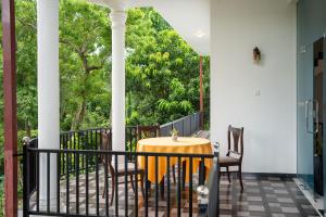a patio with a table and chairs on a porch at JAMI River Side Hotel & Yala Safari Place in Tissamaharama