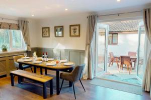 una sala da pranzo con tavolo e sedie e un patio di Woodland House a Tomatin
