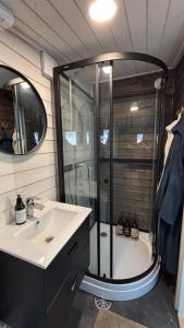 a bathroom with a shower and a sink and a tub at Mystical Lapland Cabin in Rovaniemi