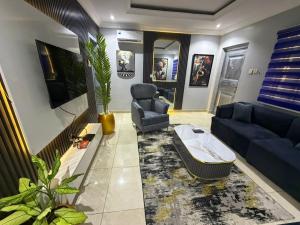 a living room with a couch and a tv at Max Court in Ikeja