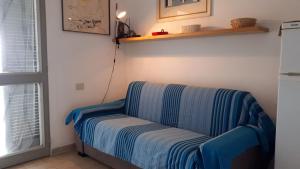 a blue stripped chair in a room with a window at Stintino Living Apartaments in Stintino