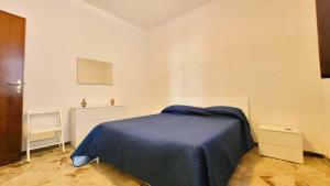 a bedroom with a bed with a blue blanket at Stintino Living Apartaments in Stintino