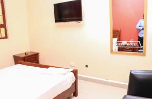 a room with a bed and a tv on the wall at Geed Hotel in Nairobi