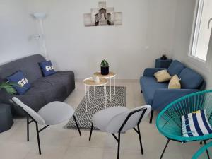 a living room with a blue couch and chairs at Villa Germaine les pieds dans l'eau in Andernos-les-Bains +29 photos