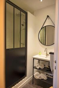 een badkamer met douche, wastafel en spiegel bij Studio Beach House à Sangatte bord de plage in Sangatte