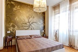 1 dormitorio con cama y lámpara de araña en Appartamento Crima Luxury, en Misano Adriatico