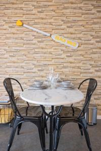 een tafel met twee stoelen en een honkbalbat aan de muur bij Studio Beach House à Sangatte bord de plage in Sangatte +48 foto's