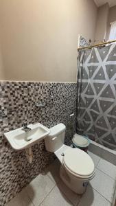 a bathroom with a toilet and a sink at Casa con Piscina Privada in Salinas