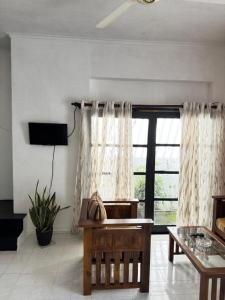 a living room with a table and a large window at The Colombo House in Battaramulla