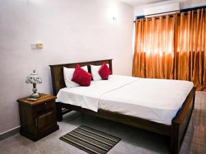 a bedroom with a large bed with red pillows at The Colombo House in Battaramulla