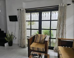 a living room with a couch and a large window at The Colombo House in Battaramulla