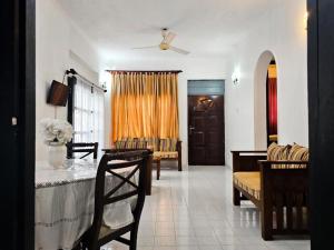 a living room with a table and chairs and a door at The Colombo House in Battaramulla