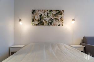 a bedroom with a bed and a painting on the wall at Sivulantie 4 109 by Holiday in Lapland in Äkäslompolo
