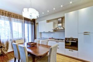 cocina con mesa de madera y armarios blancos en Appartamento Crima Luxury, en Misano Adriatico