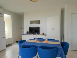 a dining room with a blue table and blue chairs at Villa Germaine les pieds dans l'eau in Andernos-les-Bains