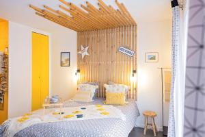 een slaapkamer met een bed met een houten hoofdeinde bij Studio Beach House à Sangatte bord de plage in Sangatte