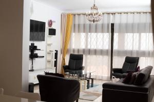 Green Valley Palace A quiet Happy Place to stay في Namulanda: غرفة معيشة مع أريكة وكراسي وطاولة