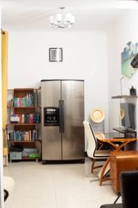 Green Valley Palace A quiet Happy Place to stay في Namulanda: ثلاجة ستانلس ستيل في غرفة مع رف للكتب