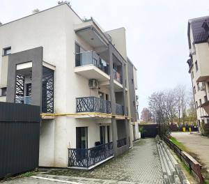 a white building with a balcony on the side of it at Apartament Zen Home in Craiova