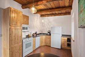 a kitchen with white appliances and wooden cabinets at Willow Street Cottages in Bluff